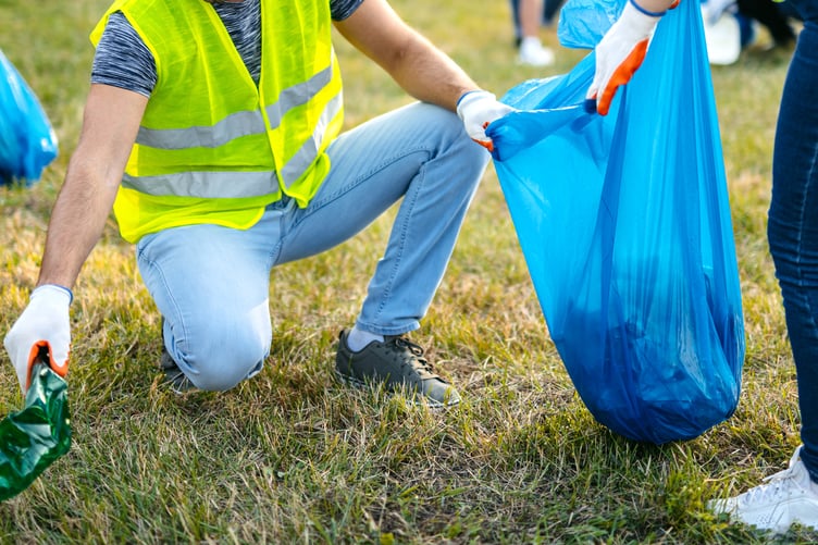 Group of young volunteers cleaning up garbage on the in the nature.