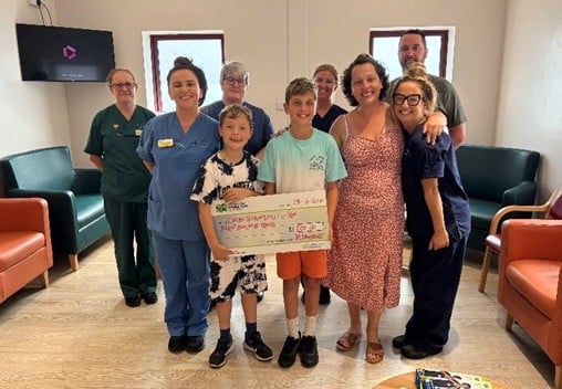 Jolene with her husband, Aled and two sons, Ellis and Gwion, with staff from the unit.