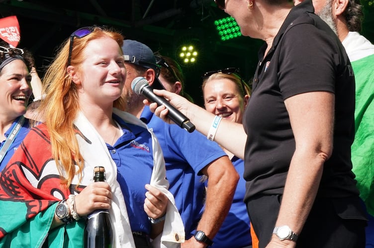 Lou Boorman proudly wears the Welsh flag on stage during Clipper Race celebrations