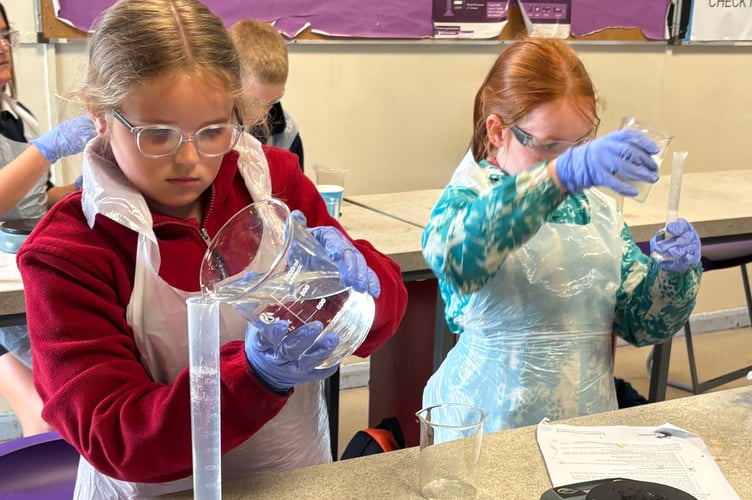 Pupils carefully measuring out their solutions