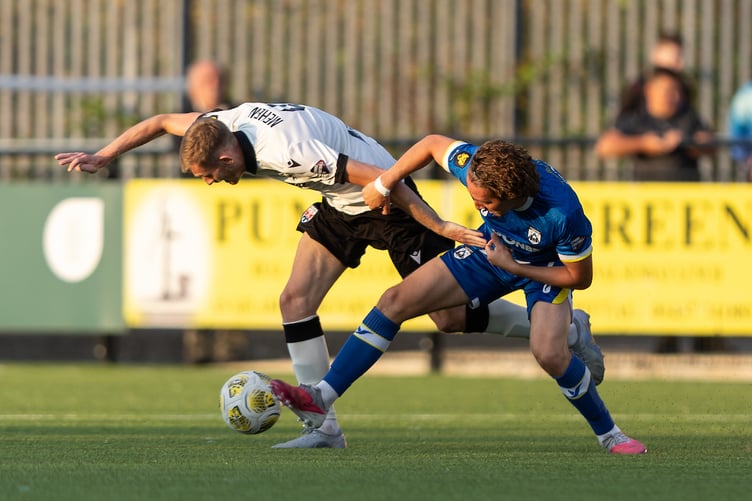 HAVERFORDWEST, WALES - 14 AUGUST 2026: Tom Mehew of Penybont and Kyle Kenniford of Haverfordwest County battle for the ball during the Novira Cymru Premier 2026/27 fixture Haverfordwest County vs Penybont at Ogi Bridge Meadow, Haverfordwest, Wales (Pic by Kara Thomas/FAW)