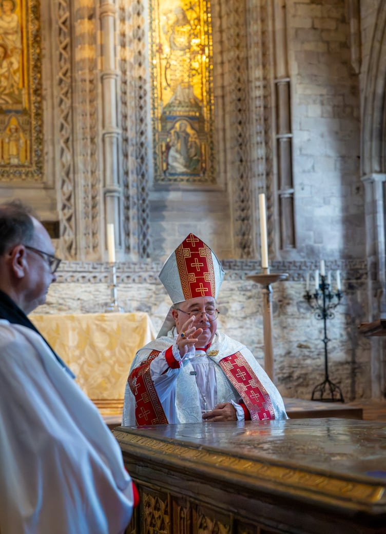 Bishop Dorrien gives a blessing at the tomb of Edmund Tudor during the service at St Davids Cathedral