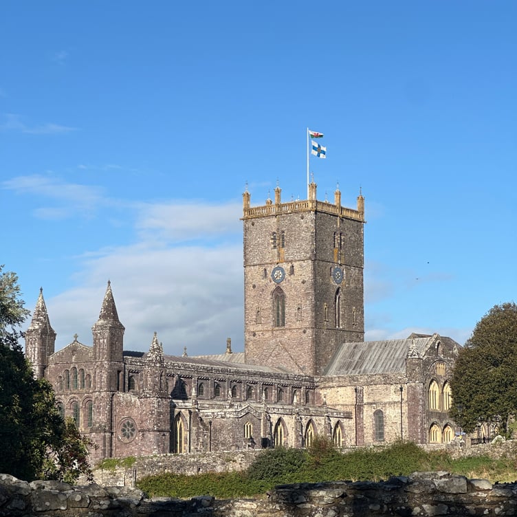 The Red Dragon and flag of the Church in Wales fly above the Cathedral