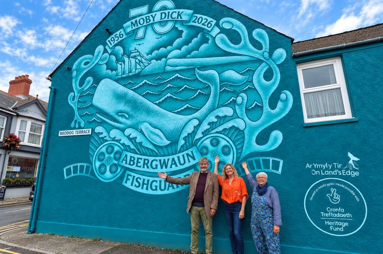 On Land’s Edge Festival committee members Dr Patrick Thomas, Blanche Giacci and Dianne Kalvik show their appreciation for Fishguard’s new Moby Dick mural created by Lloyd the Graffiti.