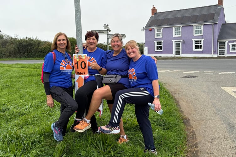 Four of the walkers taking part in the Pembrokeshire Dawn Walk, wearing t-shirts created for the event