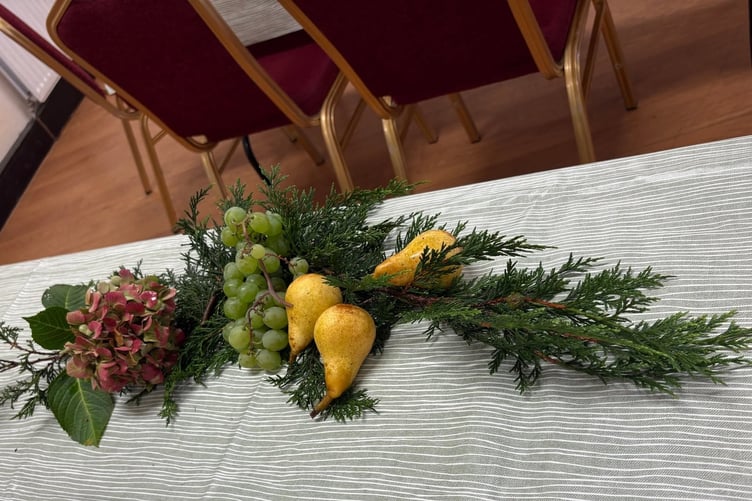 Table decoration with pears, grapes and foliage