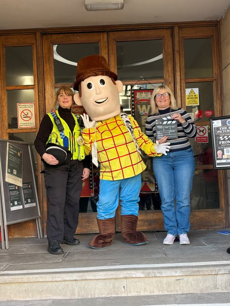 Pembroke Dock Pater Picture House cinema Toy Story launch Nadia, Woody (Cllr Denise Martin in Toy Story character costume) and Cllr Tracy George at the Pater Hall entrance