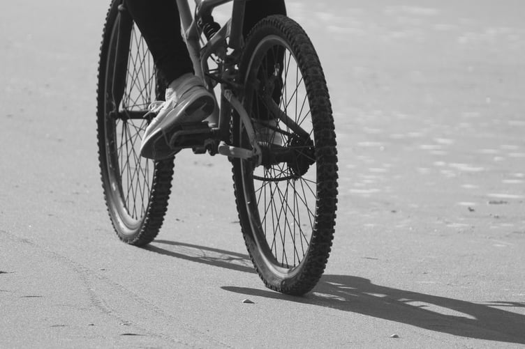 Feet and wheels of a moving cyclist. Black and white photo