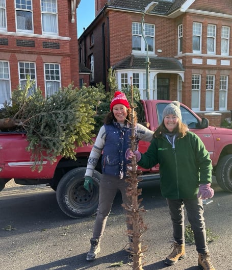 Two volunteers with their van collecting Christmas trees to be recycled for Tŷ Hafan Children's Hospice last year.